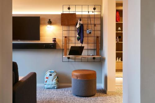 a living room with a couch and a stool and a television at Moxy Chester in Chester