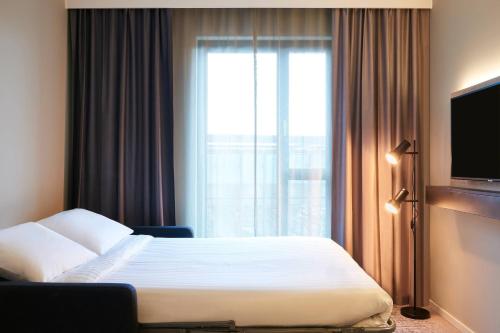 a hotel room with a bed and a window at Moxy Chester in Chester