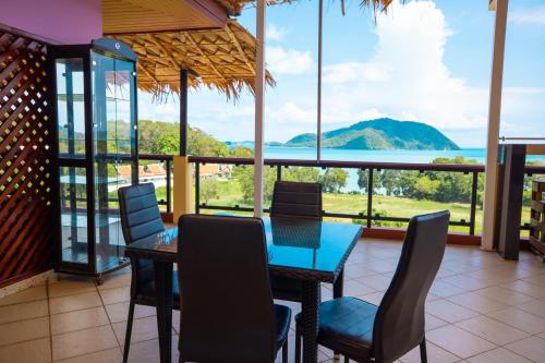 a dining room with a table and chairs and a view of the ocean at Kana Hotel Phuket普吉岛卡娜酒店 in Rawai Beach