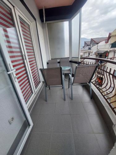 a balcony with chairs and a table and windows at Petreski Apartments 1 in Ohrid