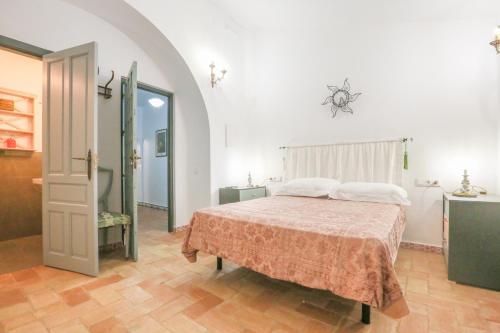 ein Schlafzimmer mit einem Bett in einem Zimmer mit einem Bad in der Unterkunft CASA SEÑORIAL CON PISCINA. CASA DONNA ISABEL in Peñaflor