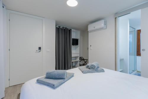a bedroom with a white bed with towels on it at 5 min dal centro - Ca'Lea - Motta di Livenza in Motta di Livenza