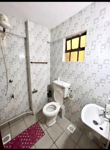 a bathroom with a toilet and a sink at SABU HOMEs in Nairobi