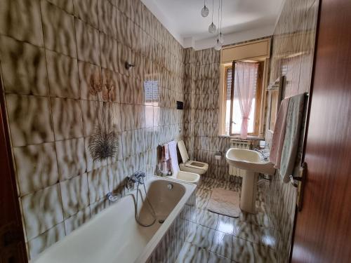 y baño con bañera, 2 lavabos y bañera. en Casa di Mamma, en Godrano