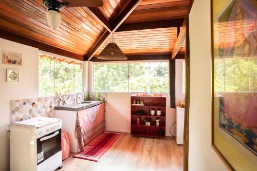 a kitchen with a wooden ceiling and a window at Pipa Surf Yoga in Pipa