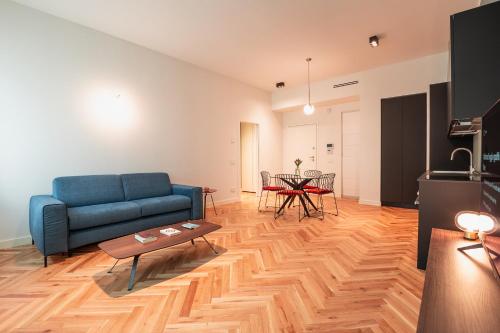 een woonkamer met een blauwe bank en een tafel bij Roma Luxe Suite in Turijn