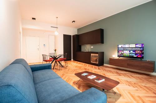 een woonkamer met een blauwe bank en een tv bij Roma Luxe Suite in Turijn