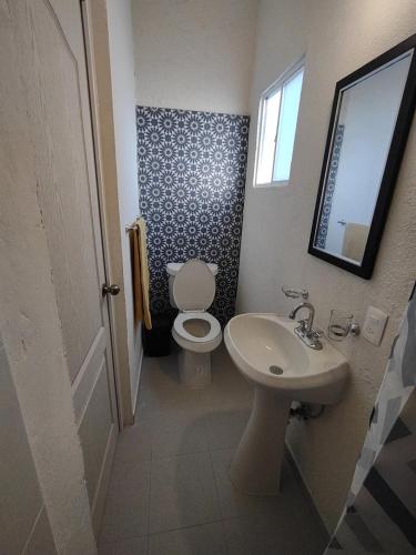 a small bathroom with a toilet and a sink at Tres Migueles, estudio Anna, cerca de la marina, zona turistica y playa in Cabo San Lucas