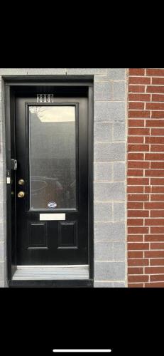 a black door with a window in a brick building at Self-service small breakfast private Room 1 in Montréal