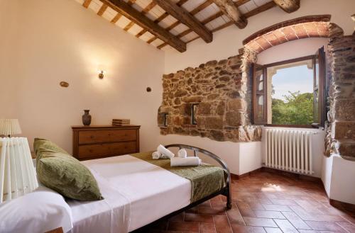 Schlafzimmer mit einem Bett und einem Fenster in der Unterkunft Masia Torre Lloreta S.XIII in Calonge