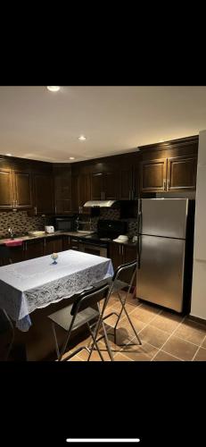 a kitchen with a table and a stainless steel refrigerator at Self-service small breakfast private Room 1 in Montréal