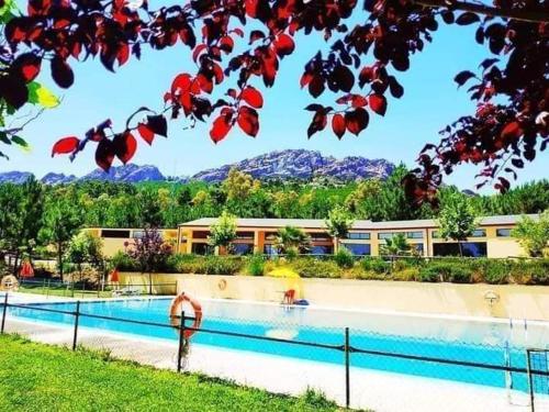 un complejo con piscina con montañas en el fondo en Camping AGUAS CLARAS en La Acena de la Borrega