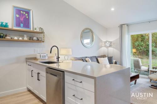 a kitchen with a sink and a living room at Close to Barton Springs and Zilker w King BR and Patio in Austin