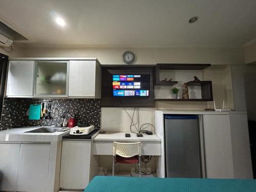 een kleine keuken met witte kasten en een wastafel bij Ov Room in Jakarta