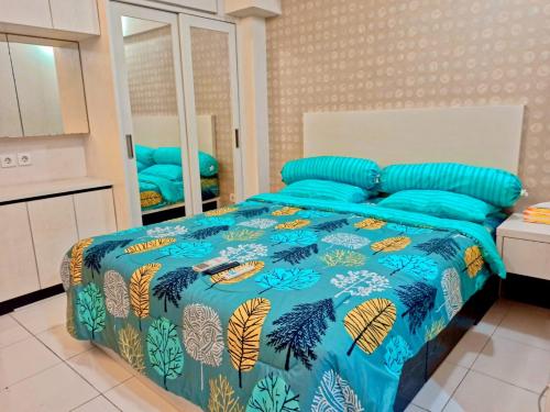 1 dormitorio con cama con edredón azul y almohadas azules en Ov Room, en Yakarta