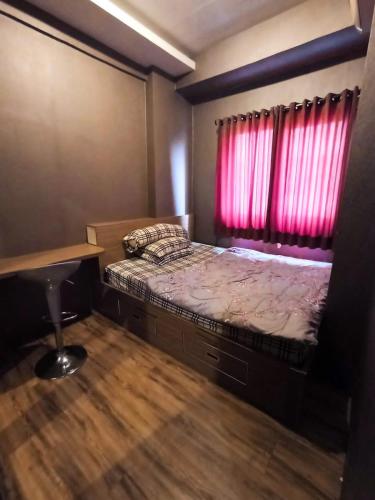 een kleine slaapkamer met een bed met een rood raam bij Ov Room in Jakarta