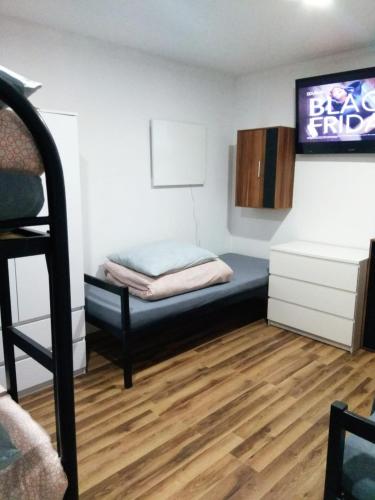Habitación pequeña con cama y TV. en Noclegi Tuszyn S, en Tuszyn