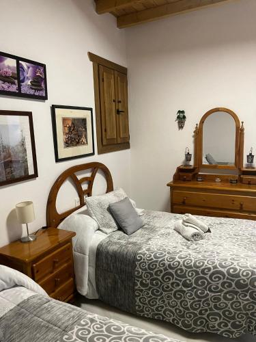 1 dormitorio con 2 camas y espejo en Apartamento patio de los leones, en Granada