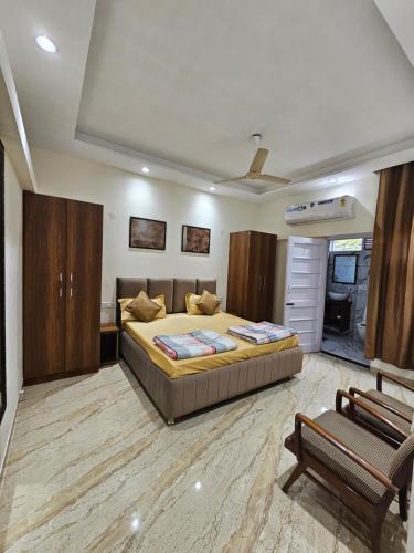 Ankhi's Villa with Parking في أمريتسار: غرفة نوم بسرير كبير وكرسي