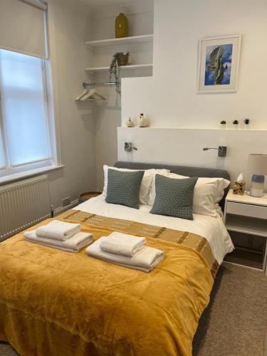 a bedroom with a large bed with towels on it at Little Gem in Kemptown Brighton in Brighton & Hove