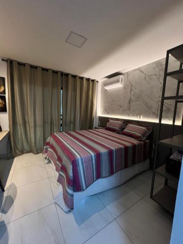 um quarto com uma cama com um cobertor listrado em Laguna Beach House em Cabedelo