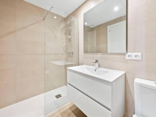 Un baño blanco con lavabo y ducha. en Denia port and beach apartment., en Denia