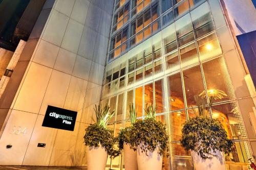 a building with three potted plants in front of it at City Express Plus by Marriott Ciudad de México Reforma El Ángel in Mexico City