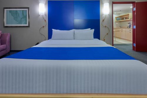 a large bed in a room with a blue wall at City Express Plus by Marriott Ciudad de México Reforma El Ángel in Mexico City