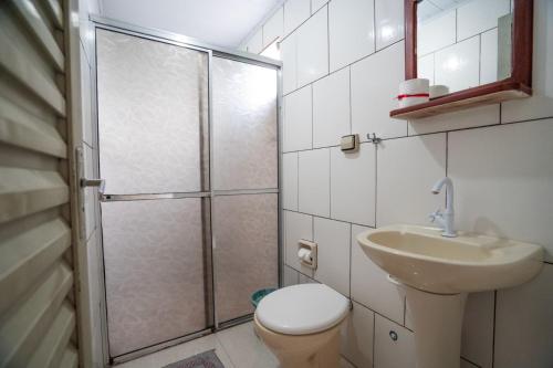 a bathroom with a shower and a toilet and a sink at Pousada Mota in Bonito