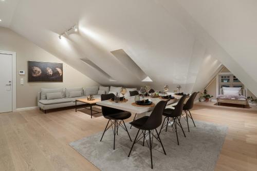 een woonkamer met een tafel en stoelen en een bank bij Arctic Homes - Premium Retreat in Tromsø