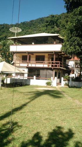 ein Gebäude mit einem Grasfeld davor in der Unterkunft Casarão Ilha de Itacuruça in Mangaratiba
