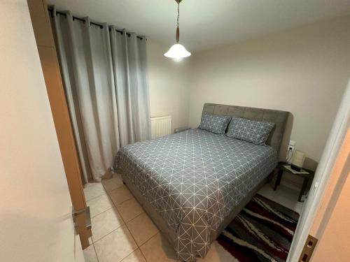 a bedroom with a bed with a gray bedspread at Palaiomonastiro mountain resort 1 in Palaiomonástiron