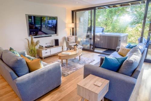a living room with two couches and a tv at Natures Retreat HM99 HOT TUB Lakeside Spa in Somerford Keynes