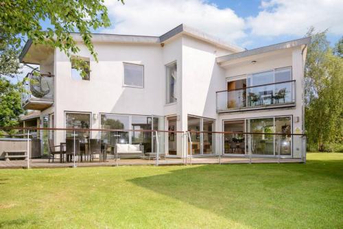 einen Blick auf ein weißes Haus mit großen Fenstern in der Unterkunft Osprey Lodge CW64 HOT TUB Lakeside Spa Property in Somerford Keynes