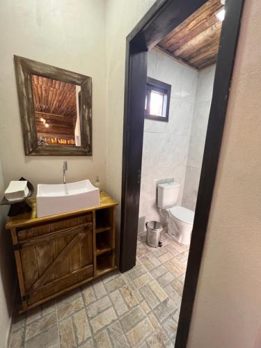 a bathroom with a sink and a toilet at Pousada Costaneira in Cambará