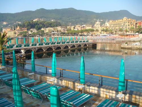 a bridge over a body of water with green umbrellas at Hotel Helios in Santa Margherita Ligure