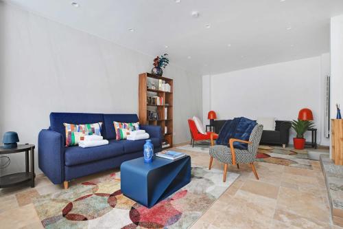 un salon avec un canapé bleu et des chaises dans l'établissement Amazing apartment 10P3BR Beaubourg - Centre de Paris, à Paris