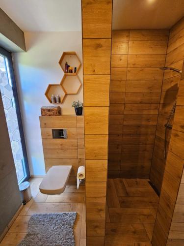 a bathroom with a shower with a wooden wall at Vila Leo in Donovaly