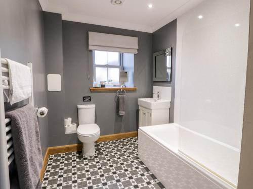 a bathroom with a toilet and a tub and a sink at The Bungalow in Maybole