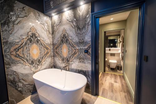 a bathroom with a bath tub and a wall at Forty-Seven in Manchester