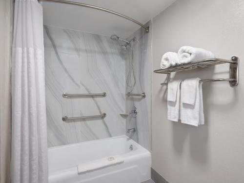 a bathroom with a shower and a sink and towels at Days-Inn by Wyndham Montgomery I-85 in Montgomery