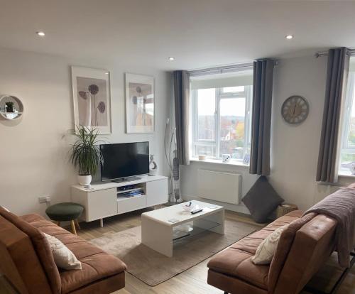 a living room with a couch and a tv at Rooftops Apartment in Bletchley