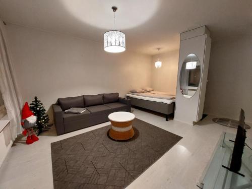 a living room with a couch and a bed at City Home Taimi in Rovaniemi