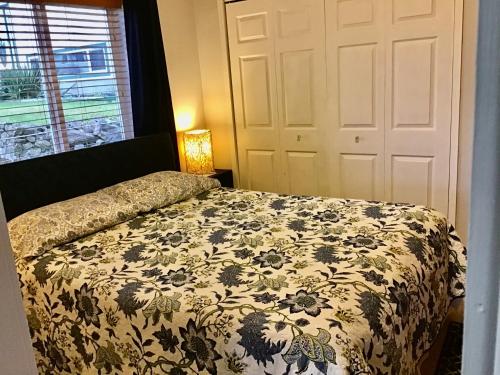 a bedroom with a bed with a floral comforter at Telco House B&B in Port Hardy