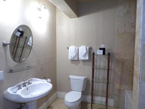 uma casa de banho com um lavatório, um WC e um espelho. em Niagara Crossing Hotel and Spa em Lewiston