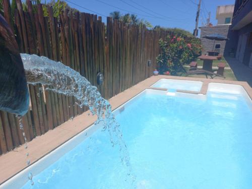 a swimming pool with a water fountain at Flats da Ilha 2 Quartos in Marechal Deodoro