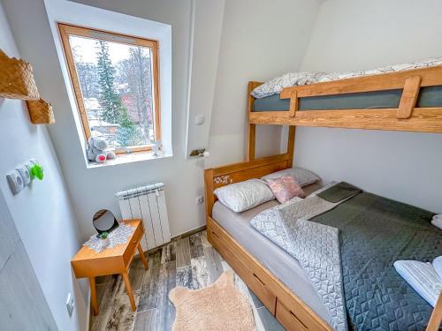 a bedroom with two bunk beds and a window at Praška zima in Jahorina