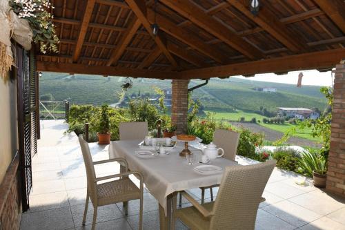 a table and chairs on a patio with a view at Agriturismo EdMo in Castiglione Tinella