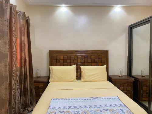 a bed with a wooden headboard in a bedroom at Residence Adja Binta Kane Sour in Dakar