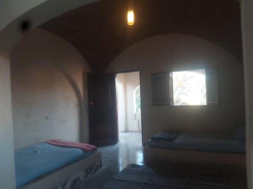 a room with two beds and a window at Oum House in Siwa